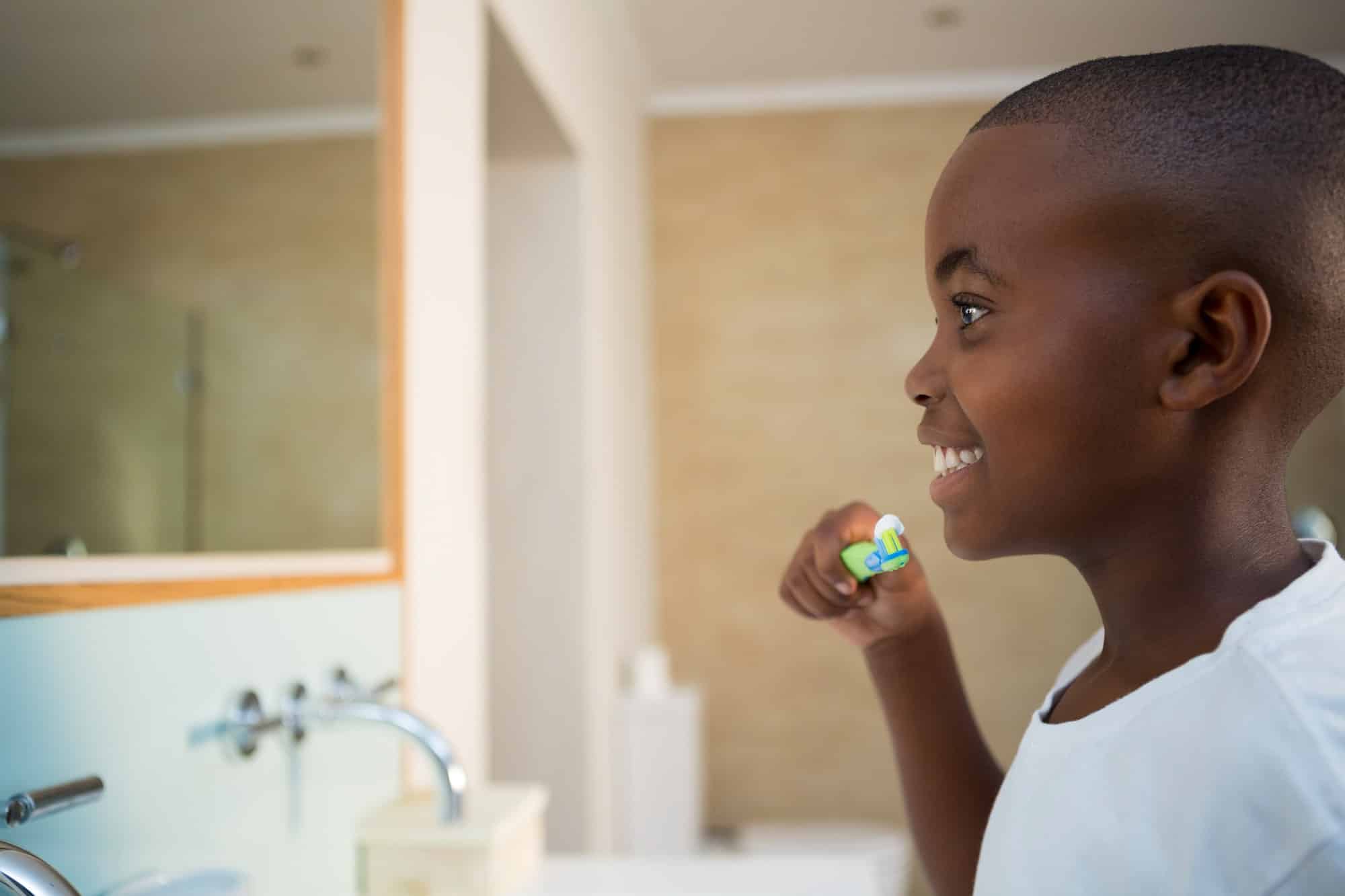 Side view of smiling boy with toothbrush